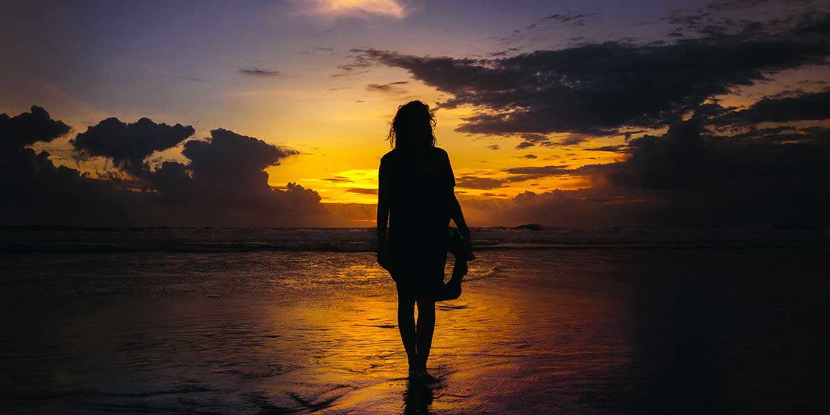 silouhette di una ragazza che cammina sul mare - vacanze estive